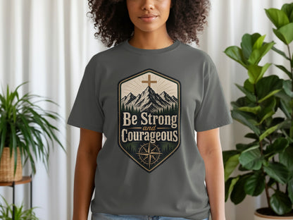 Grey t-shirt with a crest graphic featuring mountains, a cross, and the text "Be Strong and Courageous".