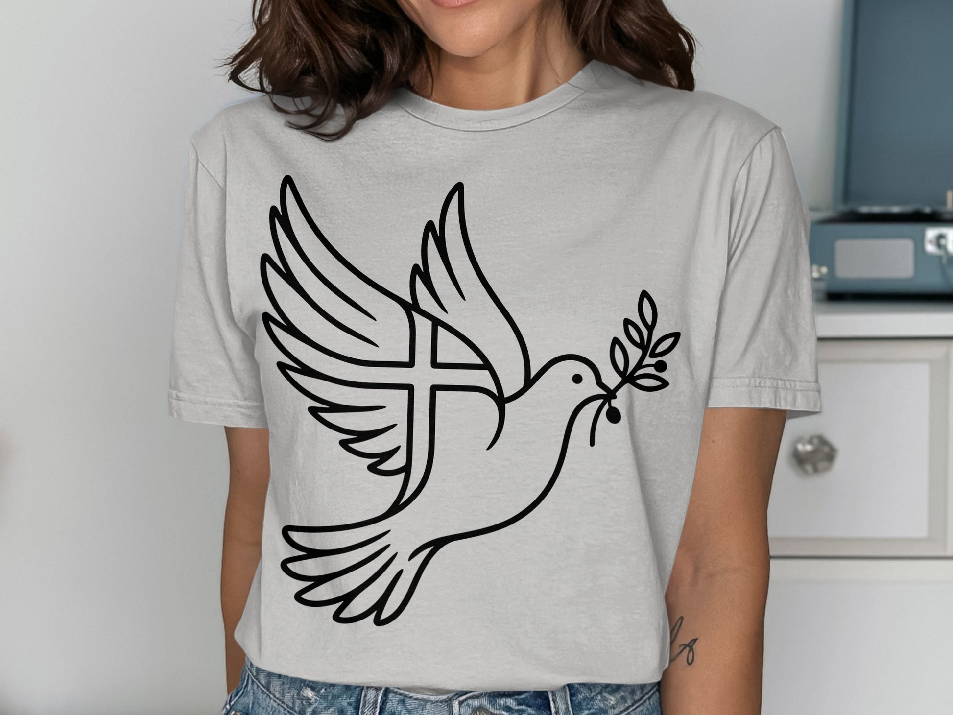 Line art dove with olive branch and cross on gray t-shirt.