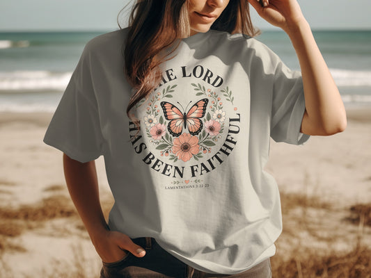Light t-shirt with a circular floral design featuring a butterfly and scripture.