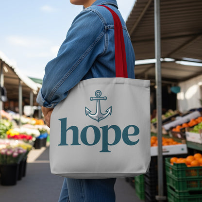 Gray tote bag with anchor and "hope" text, held by a person in denim.