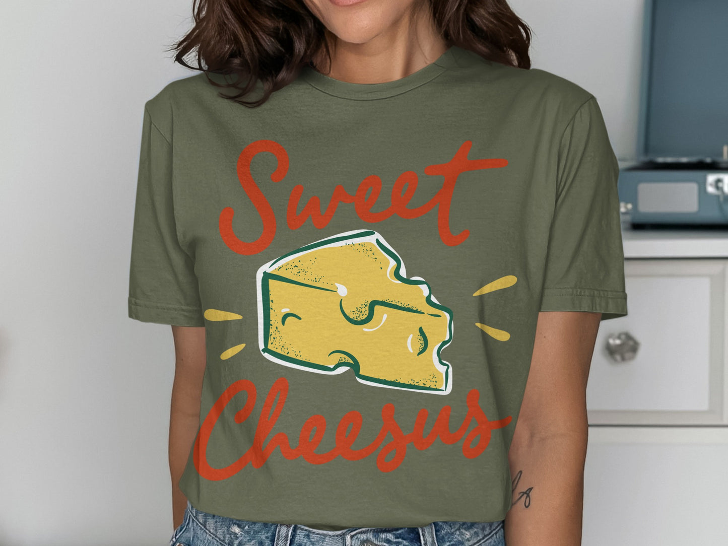 Green t-shirt with "Sweet Cheesus" text and cartoon cheese wedge.