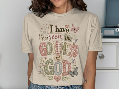 Cream t-shirt with "I have seen the goodness of God" text and floral accents.
