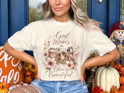Cream t-shirt with a vintage camera and flowers graphic that reads "God Makes the Blurry Beautiful".