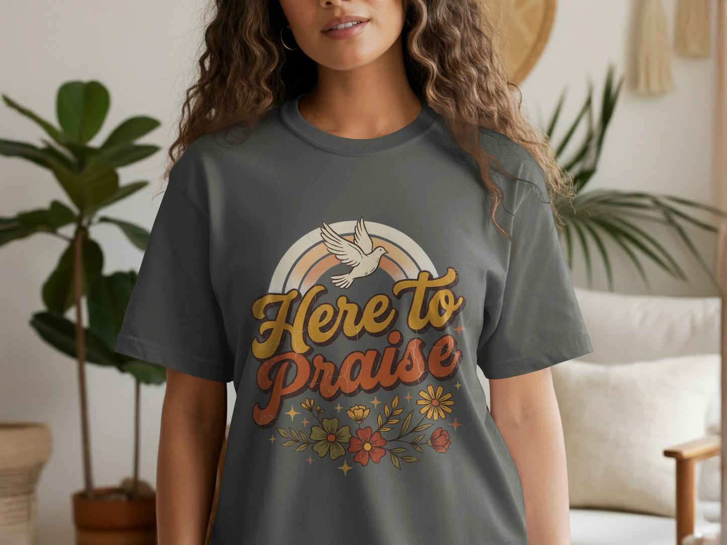 Dark grey t-shirt with 'Here to Praise' text, a rainbow, and flowers.