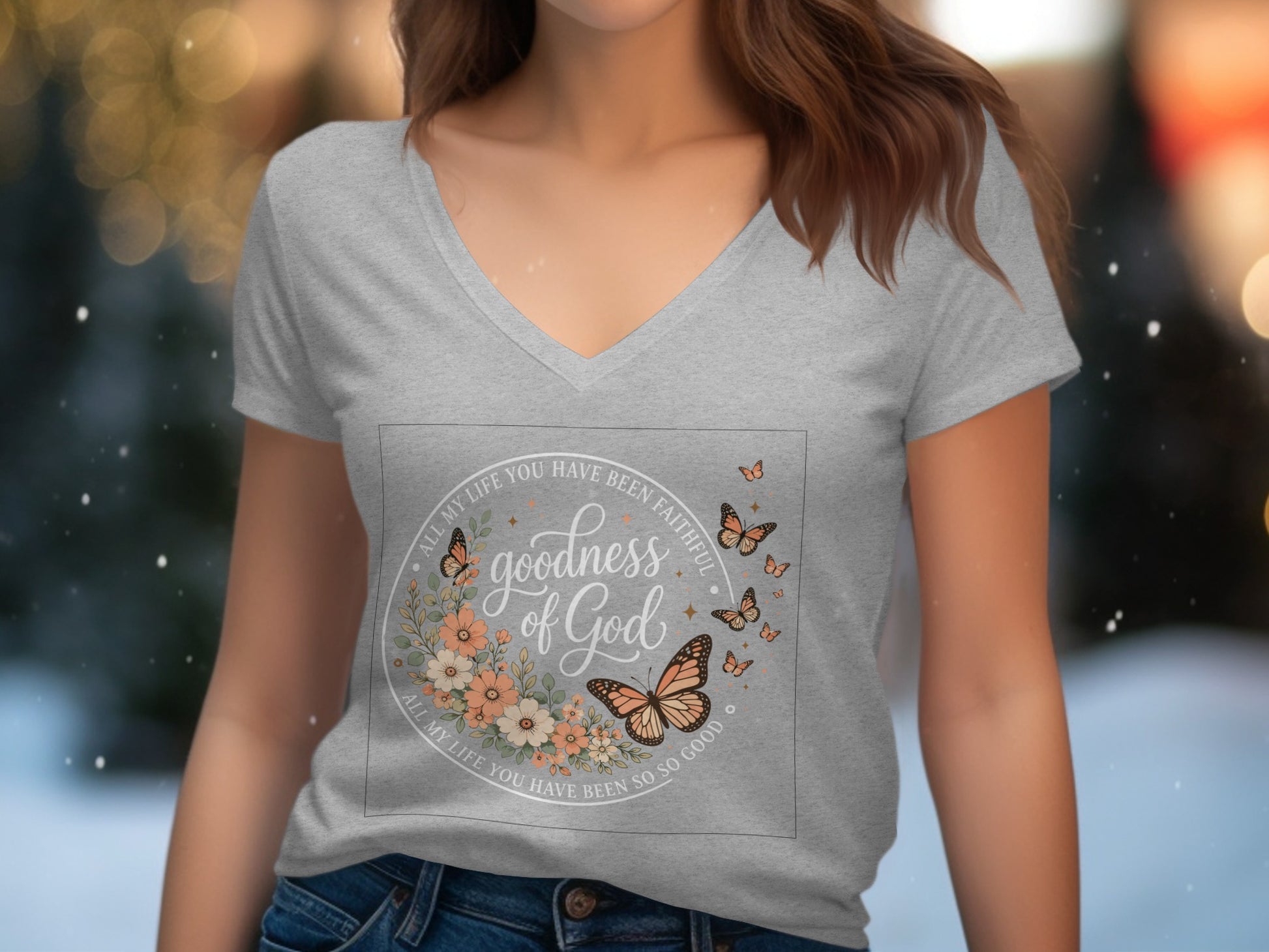 Grey v-neck t-shirt with "goodness of God" floral and butterfly graphic.