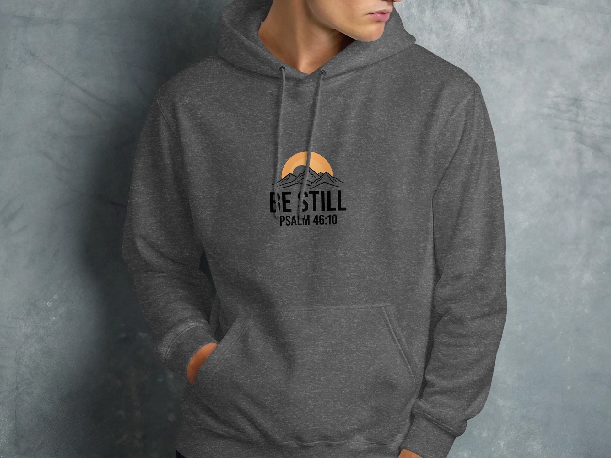 Dark grey hoodie with "Be Still" and Psalm 46:10 graphic.