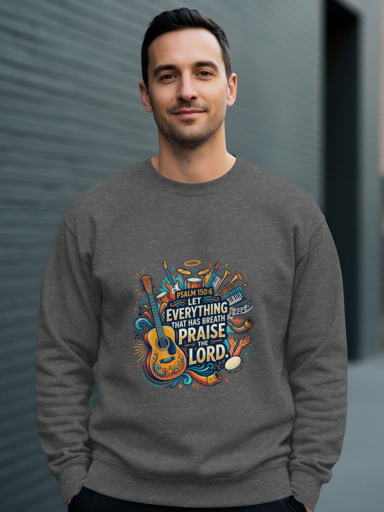 Man wearing a gray sweatshirt with a colorful musical instrument graphic and psalm text.