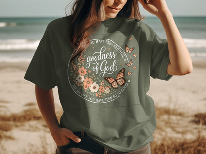 Green t-shirt with "goodness of God" floral and butterfly design.