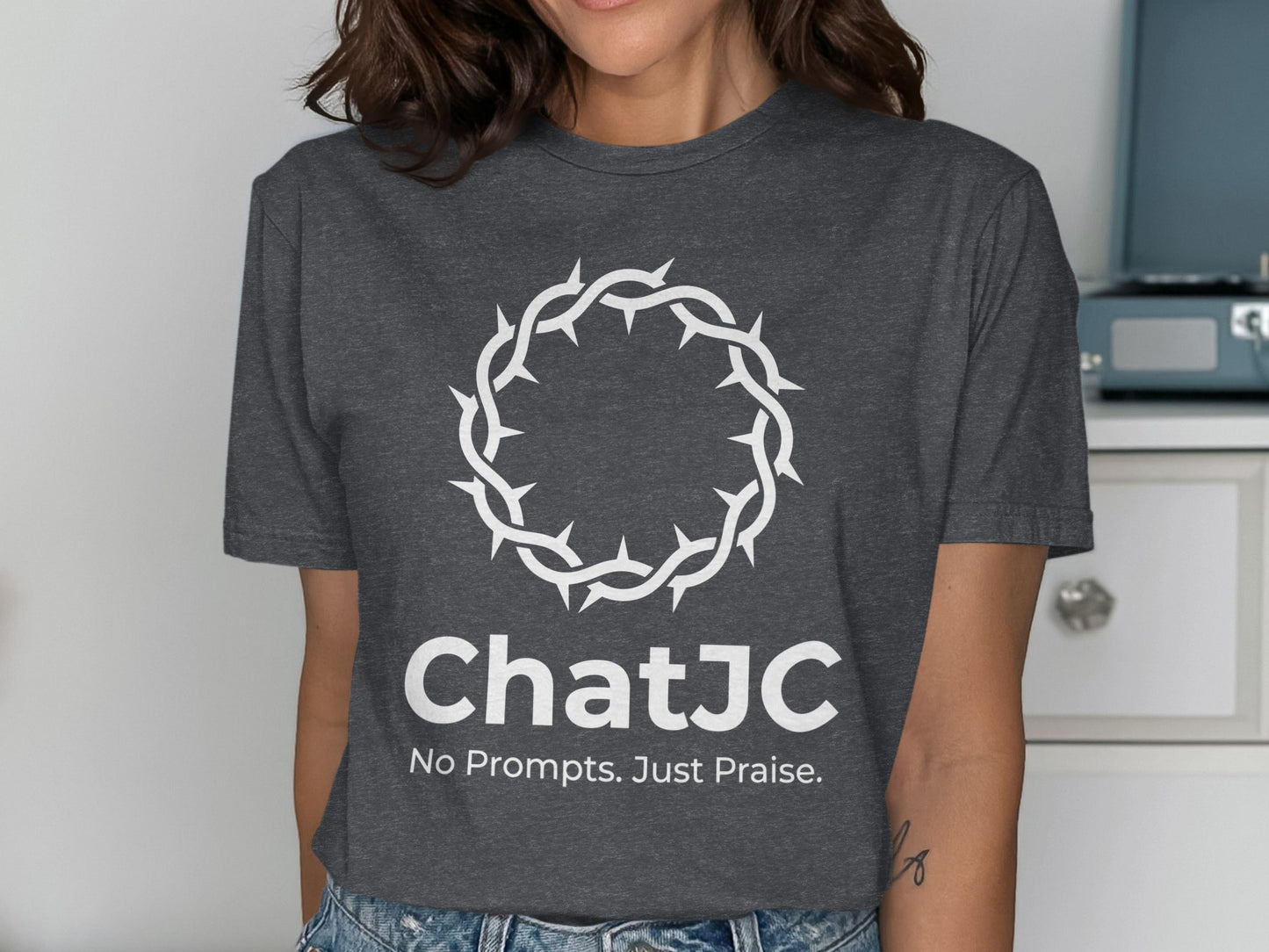 Dark grey t-shirt with white crown of thorns and "ChatJC No Prompts. Just Praise."