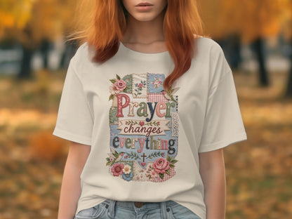 White t-shirt with "Prayer changes everything" text and floral patchwork design.