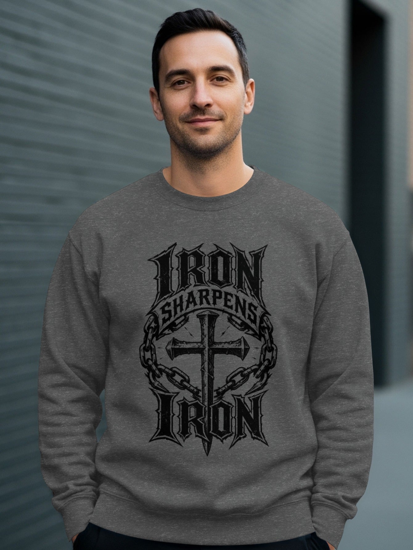 Man wearing gray sweatshirt with "Iron Sharpens Iron" text and cross design.