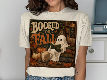 Booked for Fall graphic with ghost reading, pumpkins, and cozy autumn elements.