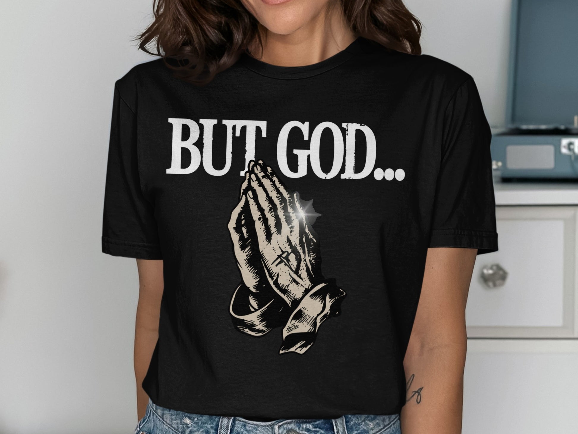 Black t-shirt with praying hands graphic and "BUT GOD..." text.
