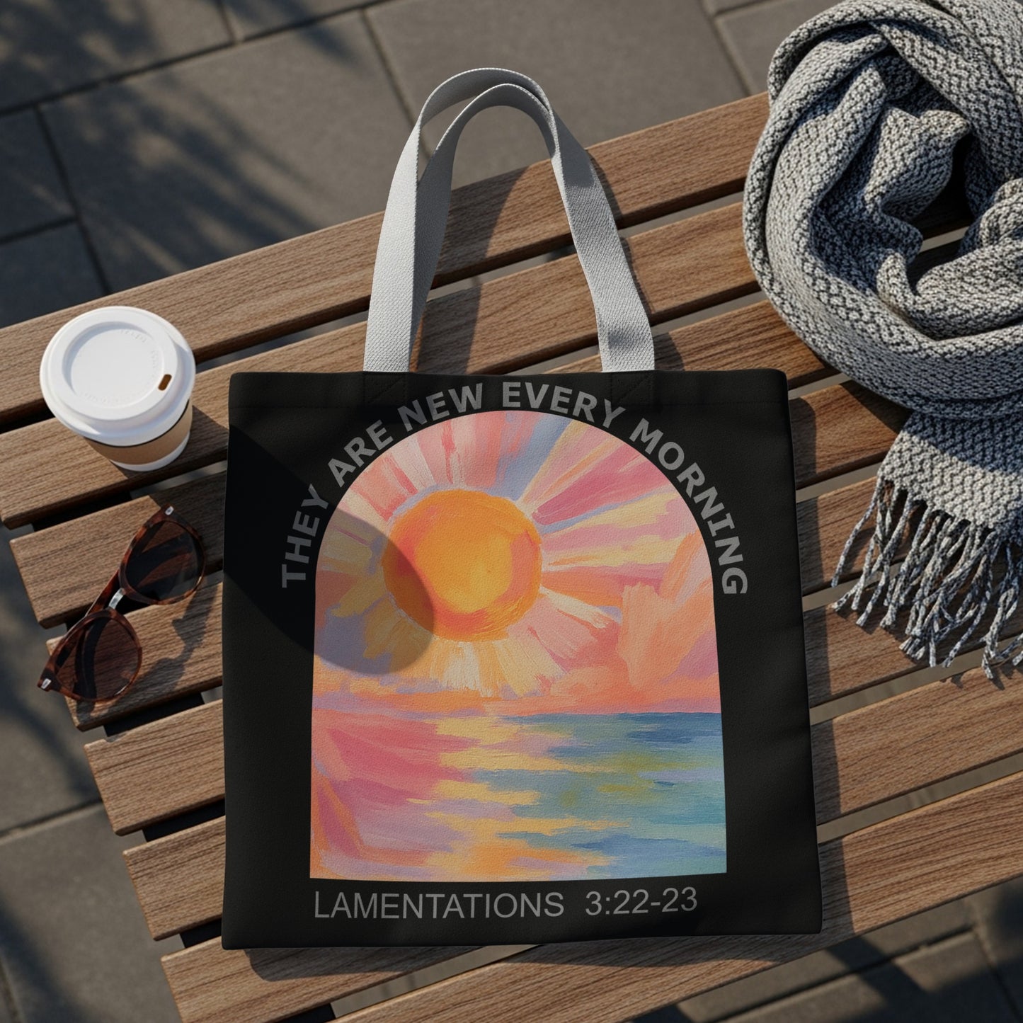 Black tote bag with sunrise over water art and "They are new every morning" text.