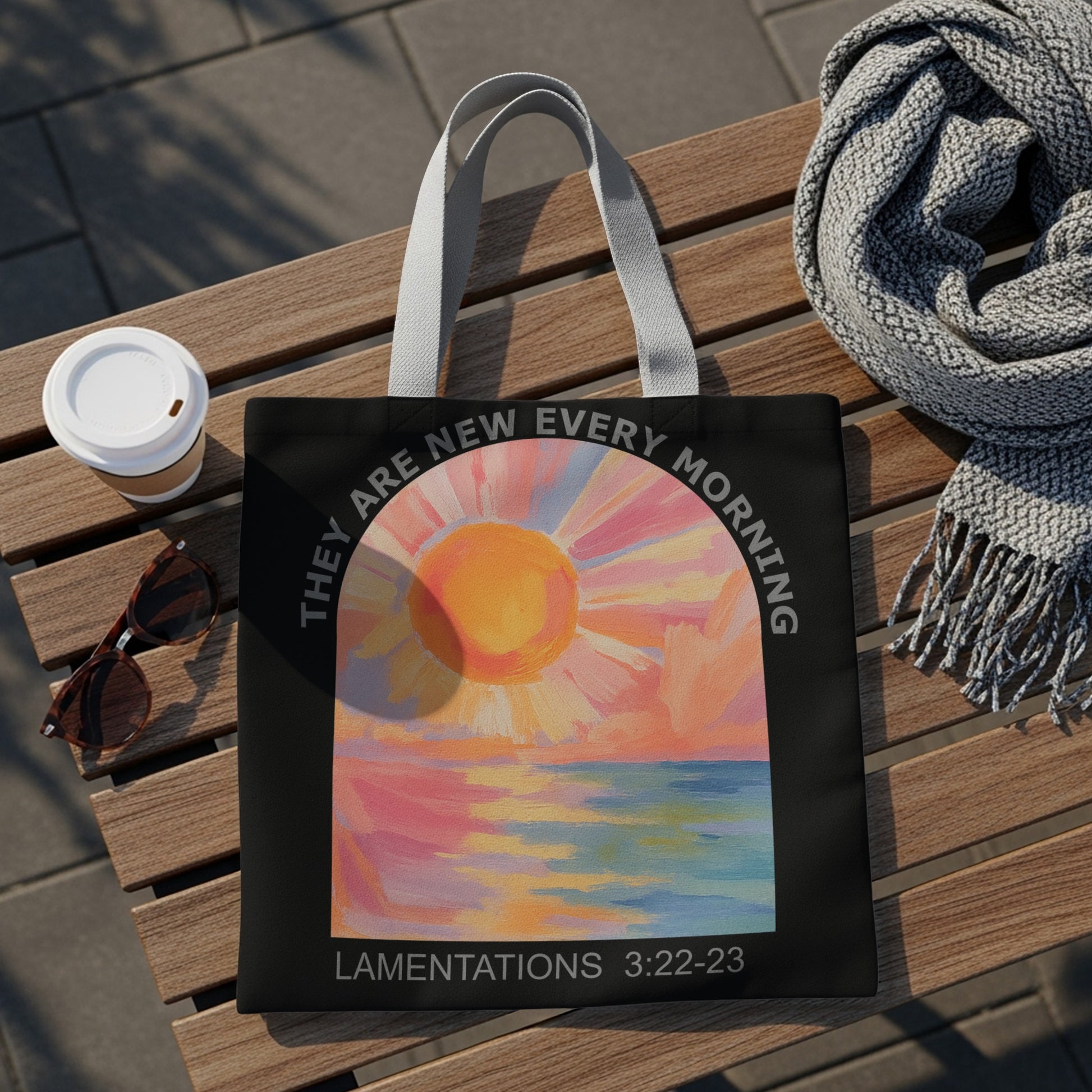 Black tote bag with sunrise over water art and "They are new every morning" text.