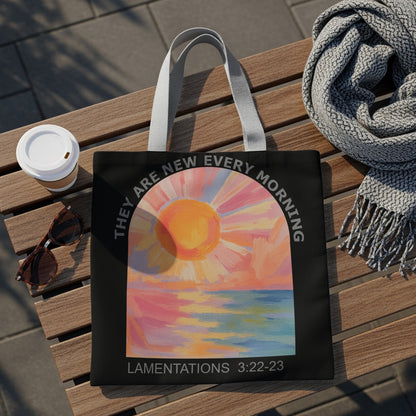 Black tote bag with sunrise over water art and "They are new every morning" text.