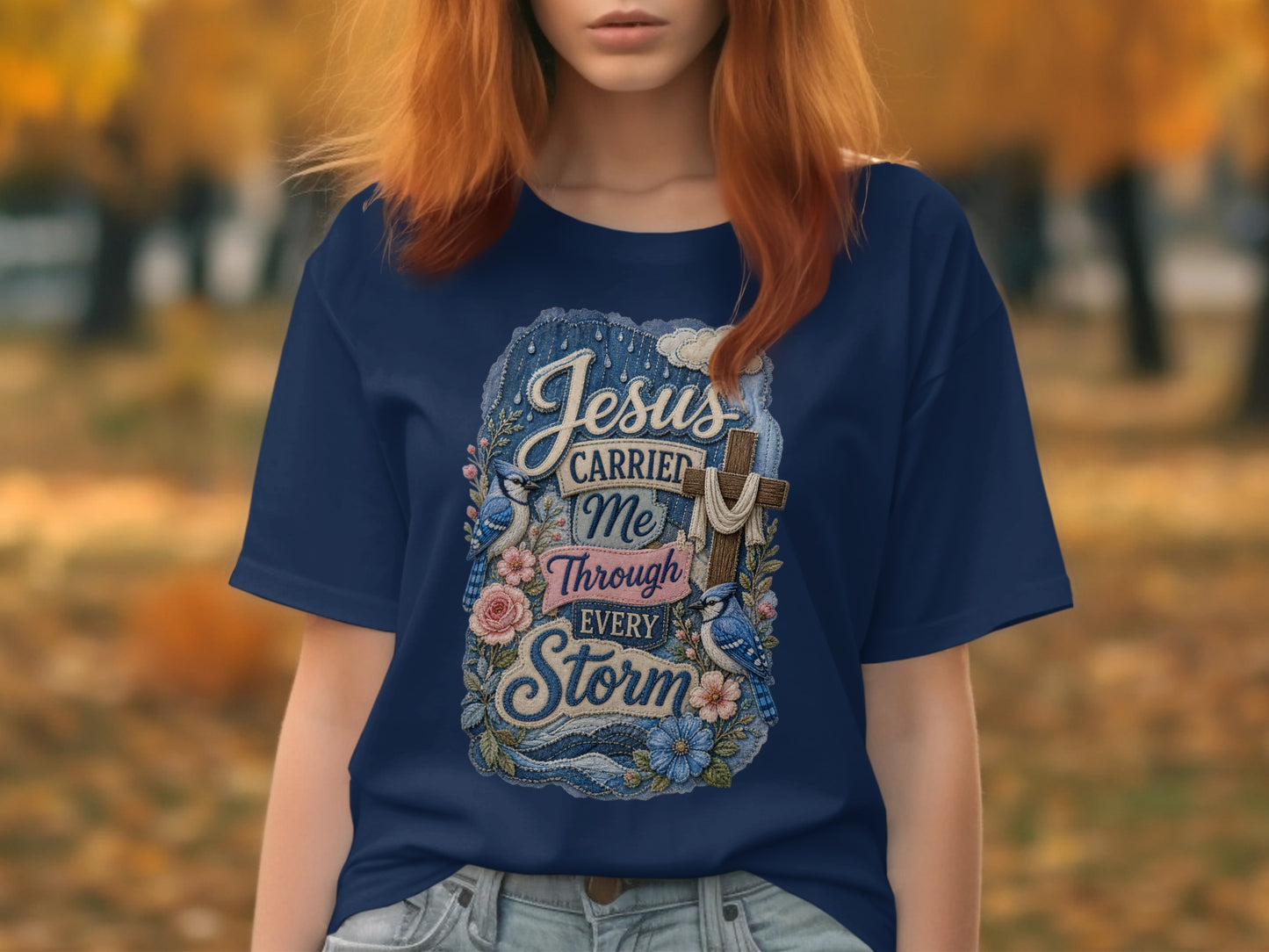 Navy t-shirt with "Jesus carried me through every storm" text and floral design.