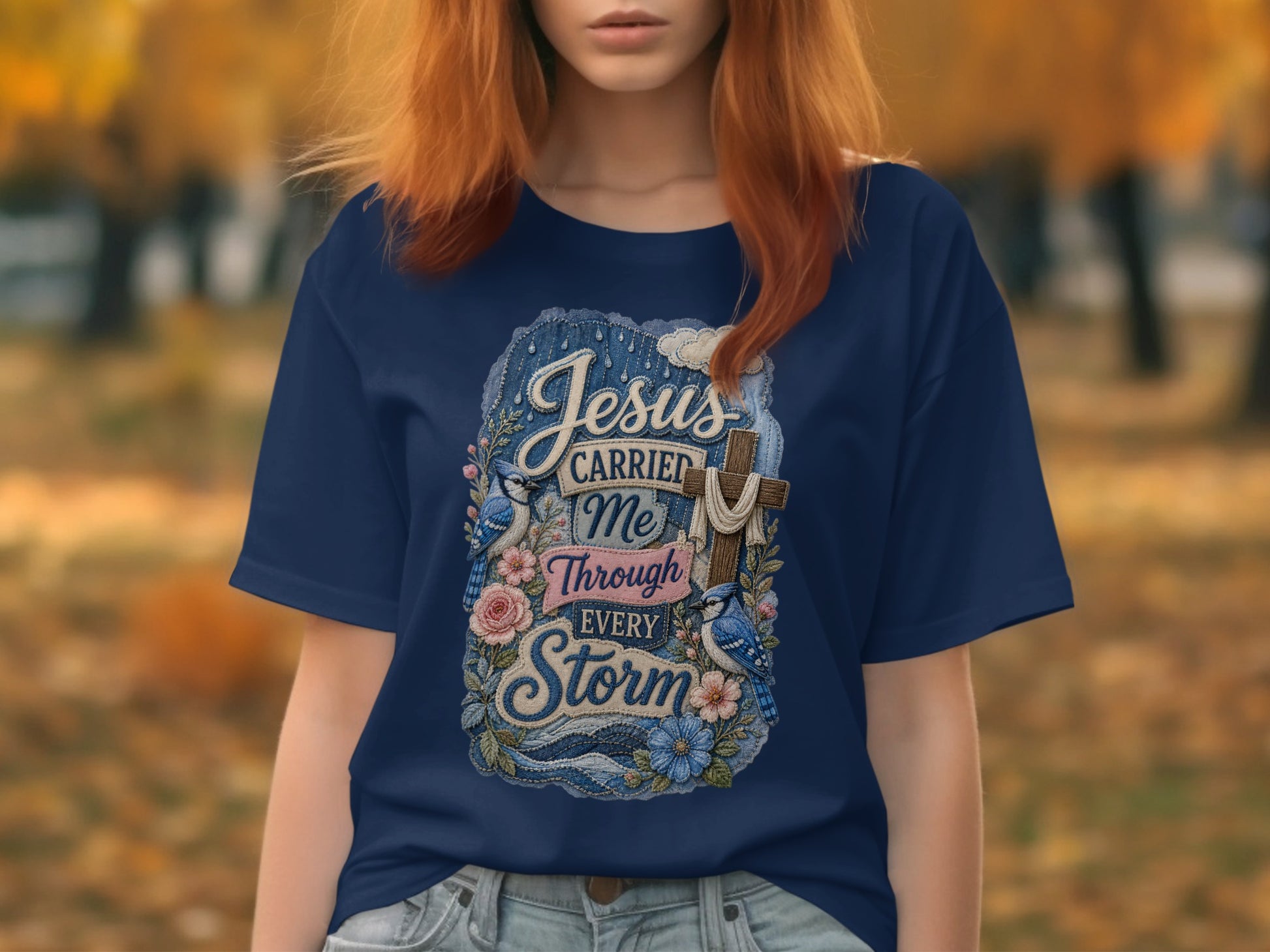 Navy t-shirt with "Jesus carried me through every storm" text and floral design.