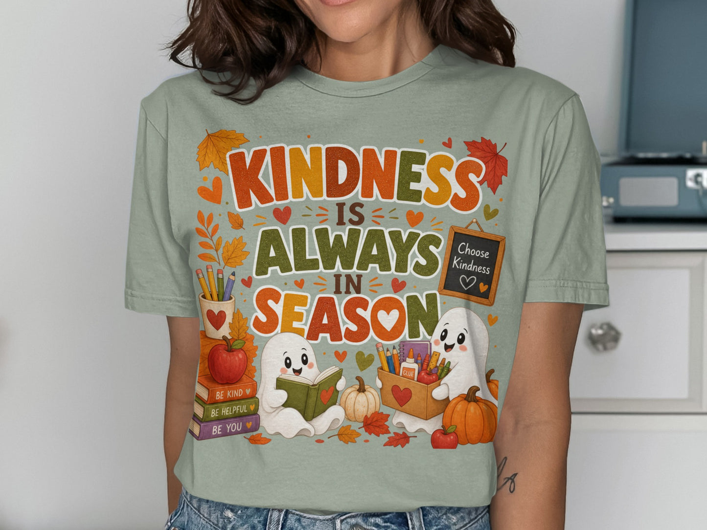 T-shirt design with ghosts, pumpkins, books, and the text "Kindness Is Always In Season".