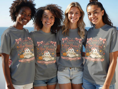 Four women model grey t-shirts with a "Couldn't Keep Him Buried" ghost design.
