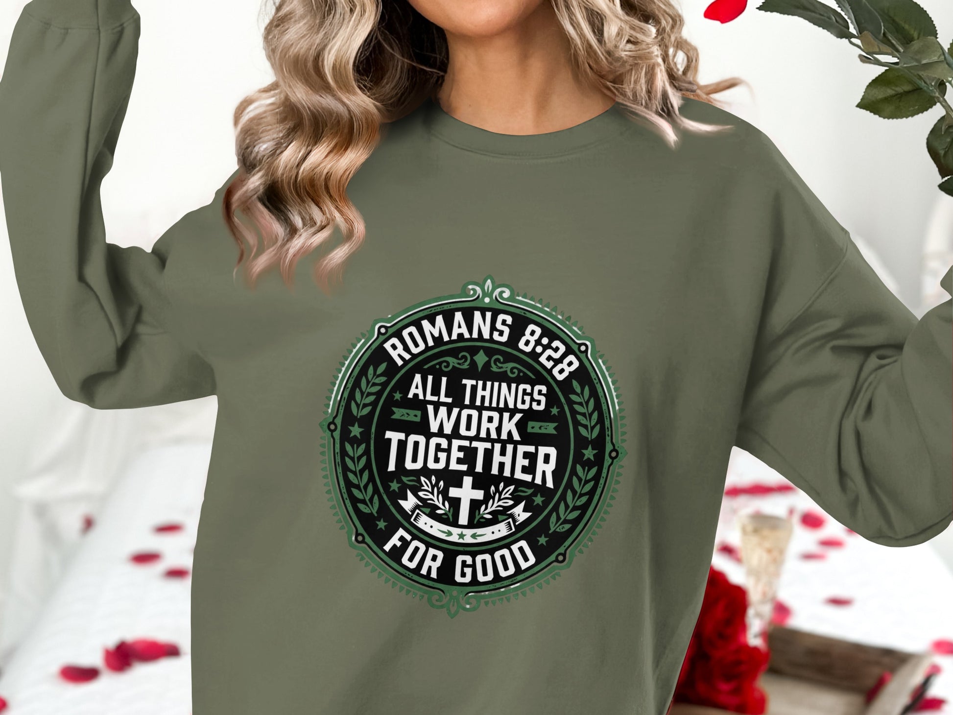 Green crewneck sweatshirt with Romans 8:28 text in a circular design.