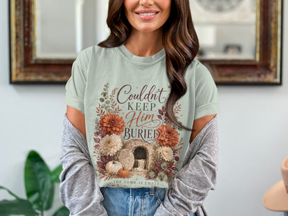 T-shirt with text "Couldn't Keep Him Buried. The Tomb is Empty."
