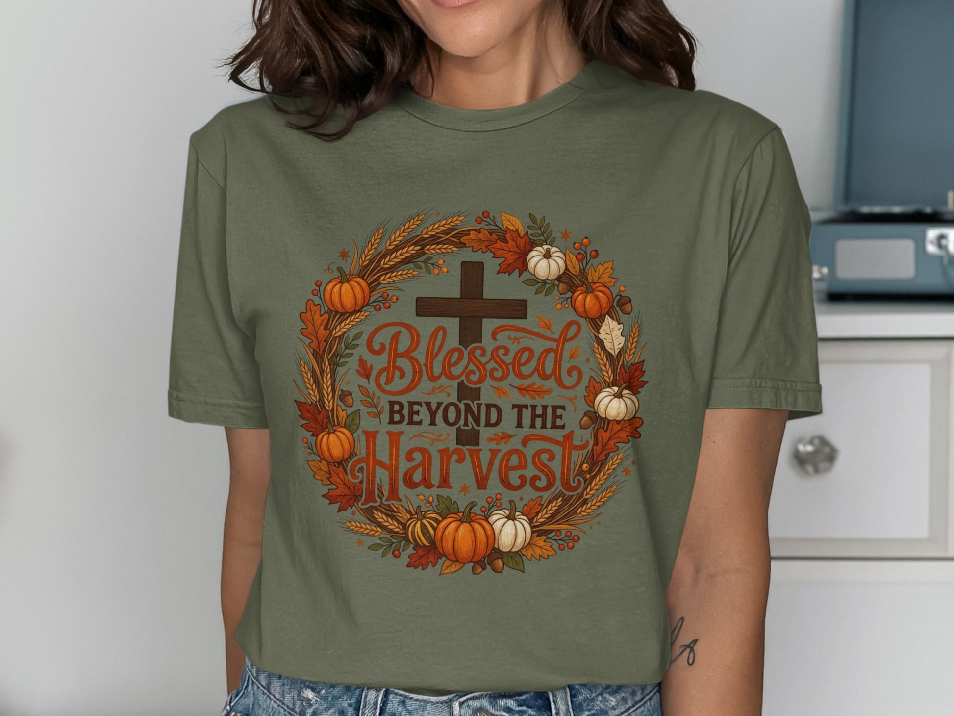 Olive green t-shirt with "Blessed Beyond the Harvest" cross and autumn wreath graphic.