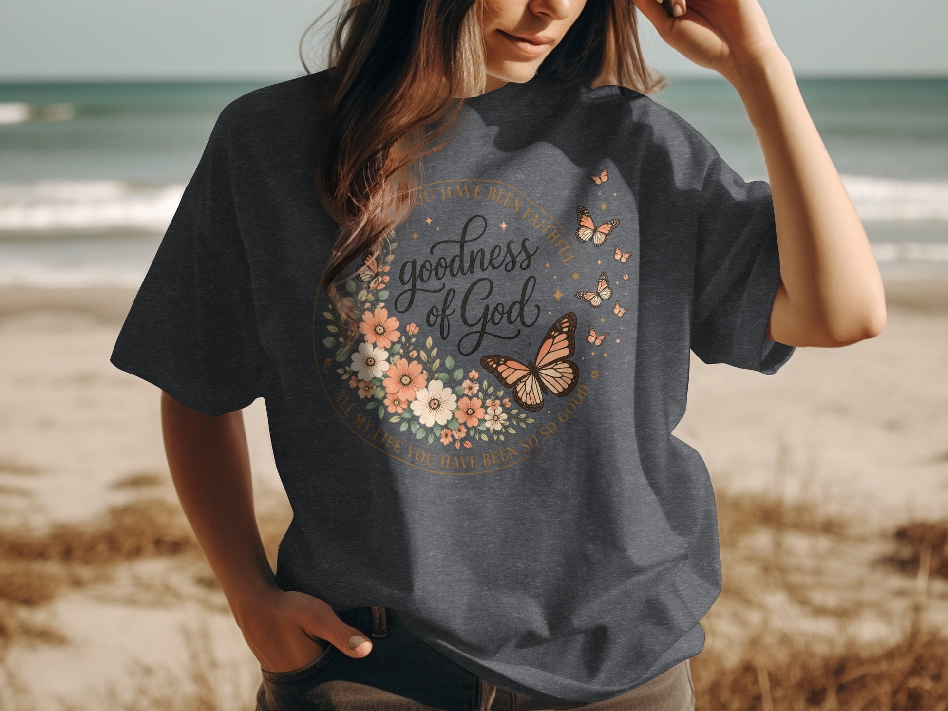 Dark grey t-shirt with floral and butterfly design and "goodness of God" text.