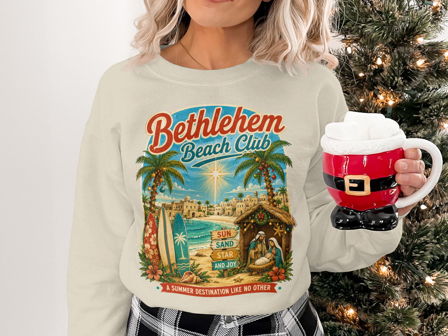 Bethlehem Beach Club sweatshirt with nativity scene, palm trees, and surfboards.