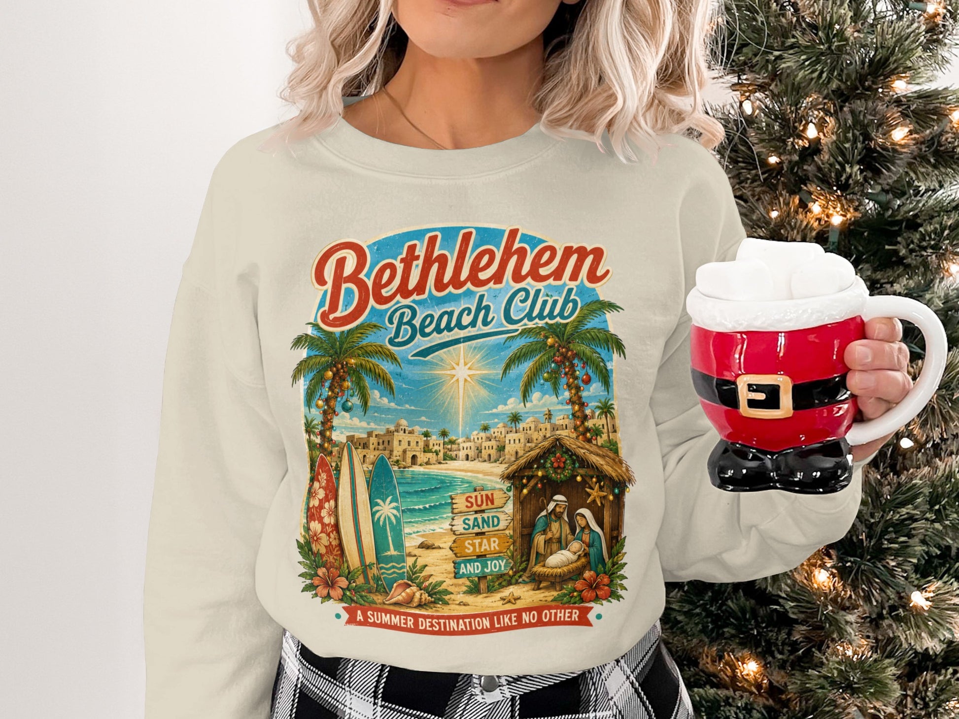 Bethlehem Beach Club sweatshirt with nativity scene, palm trees, and surfboards.