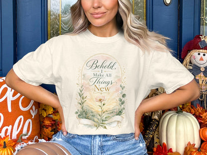 Cream t-shirt with watercolor floral design and text "Behold, I Make All Things New"