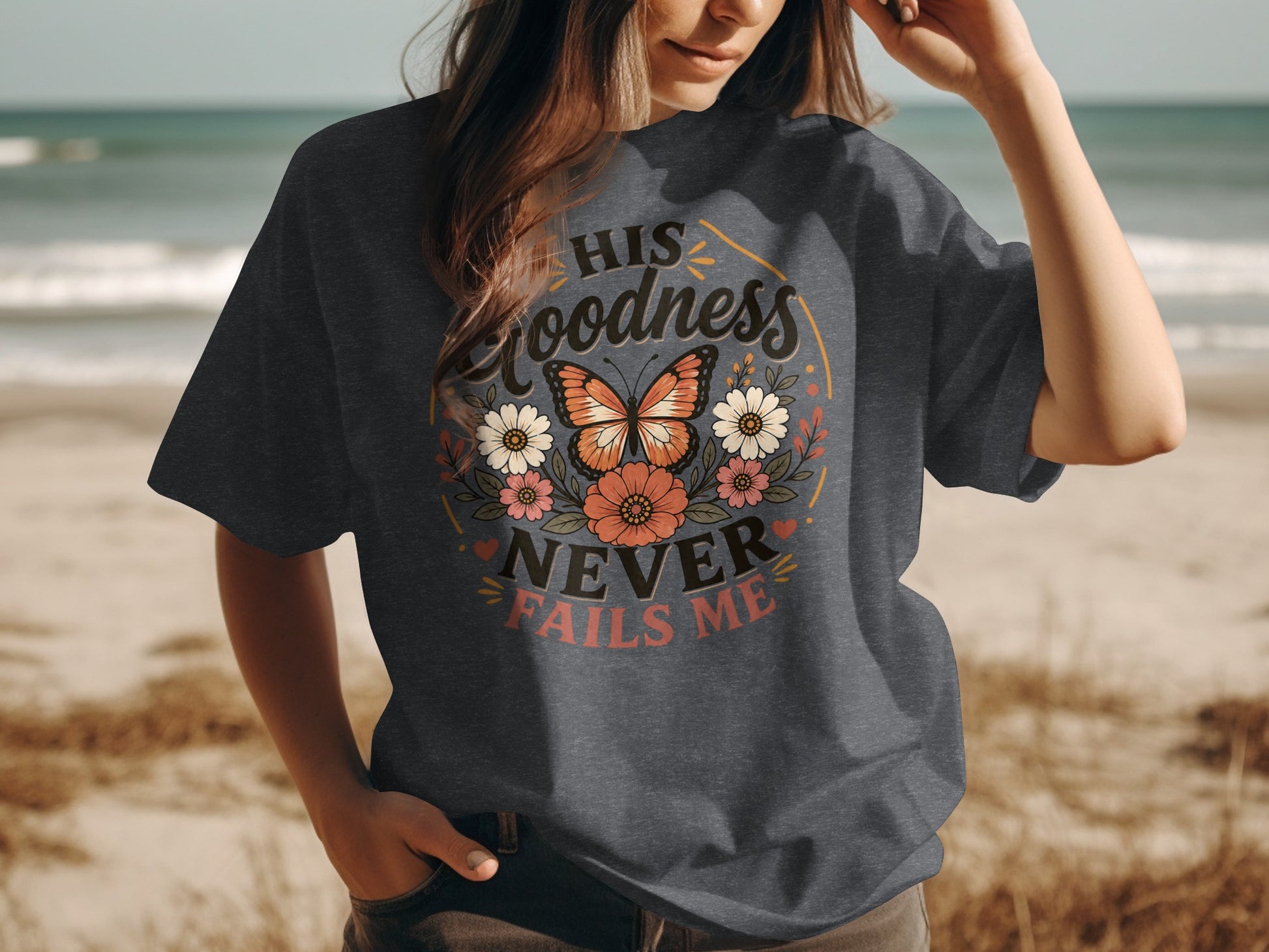 Dark grey t-shirt with "His Goodness Never Fails Me" text and floral butterfly design.