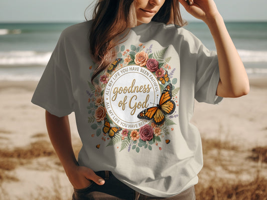 T-shirt with floral wreath, butterflies, and "Goodness of God" text.
