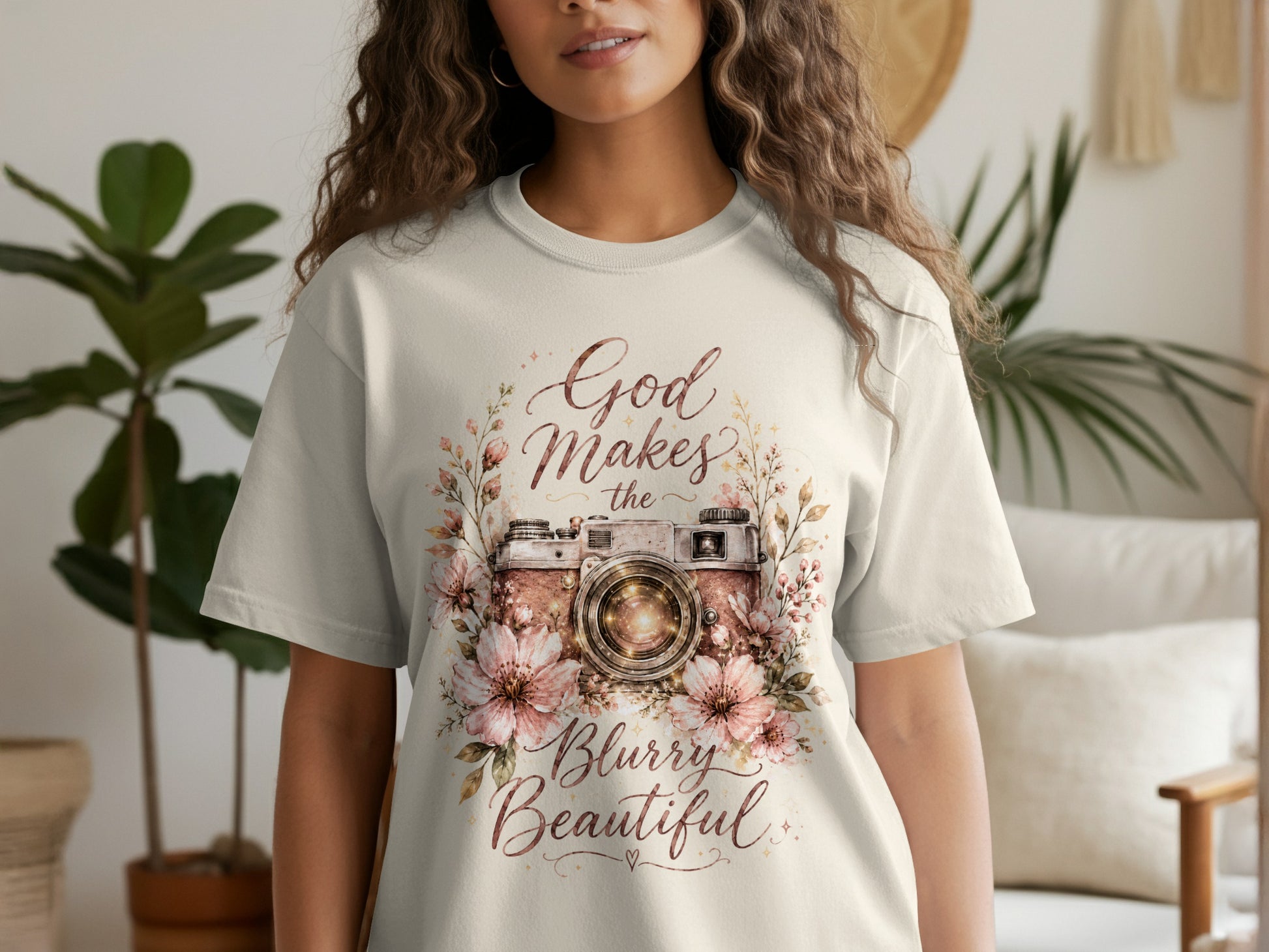 Light cream t-shirt with floral camera graphic and text "God Makes the Blurry Beautiful."