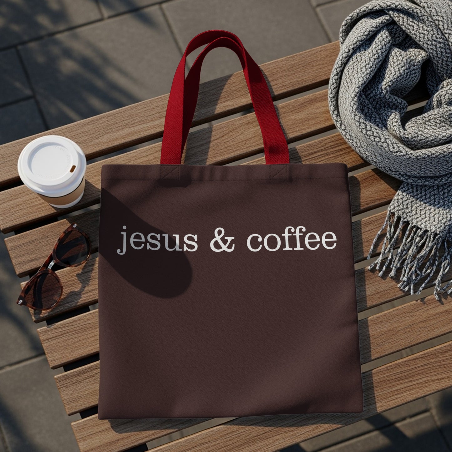 Brown tote bag with white text "jesus & coffee" and red handles.